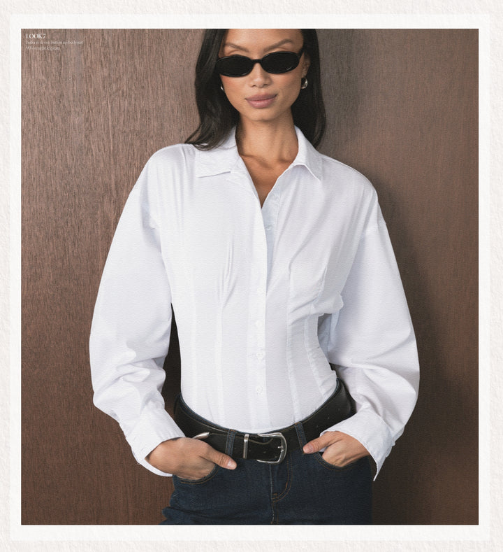 Woman wearing a white shirt and dark pants against a brown background